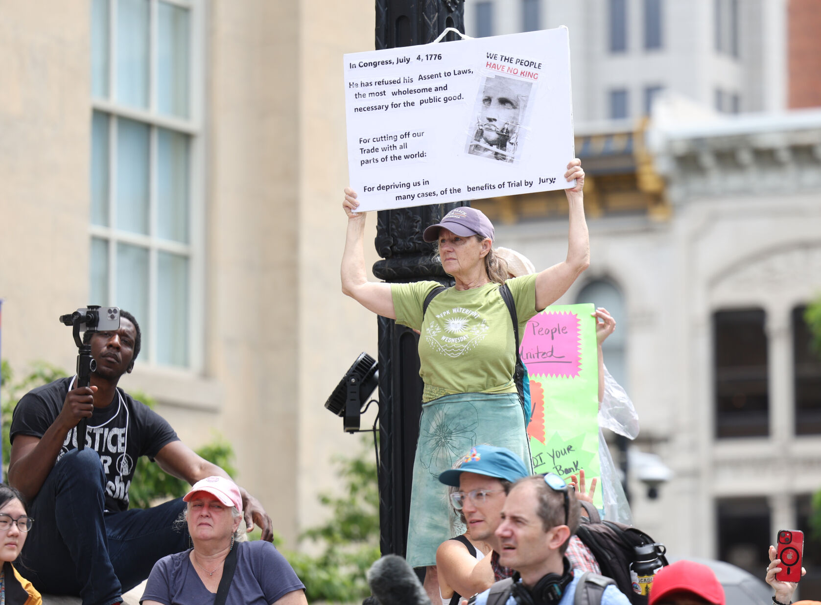 Person stands up with sign at No Kings rally.JPG
